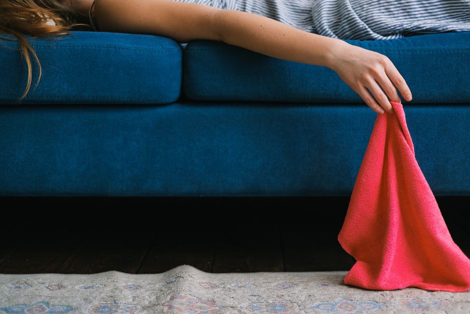 Technician performing professional upholstery cleaning on a fabric sofa